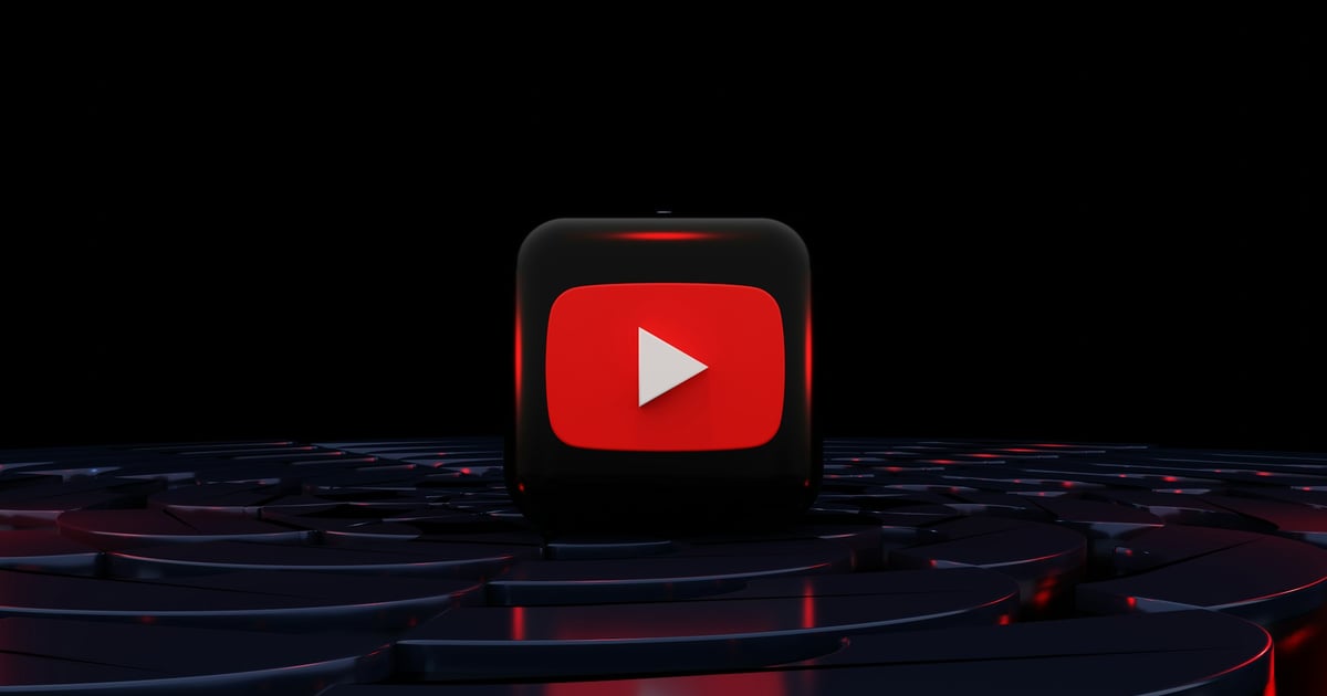 3D YouTube play button logo glowing red on a dark reflective surface
