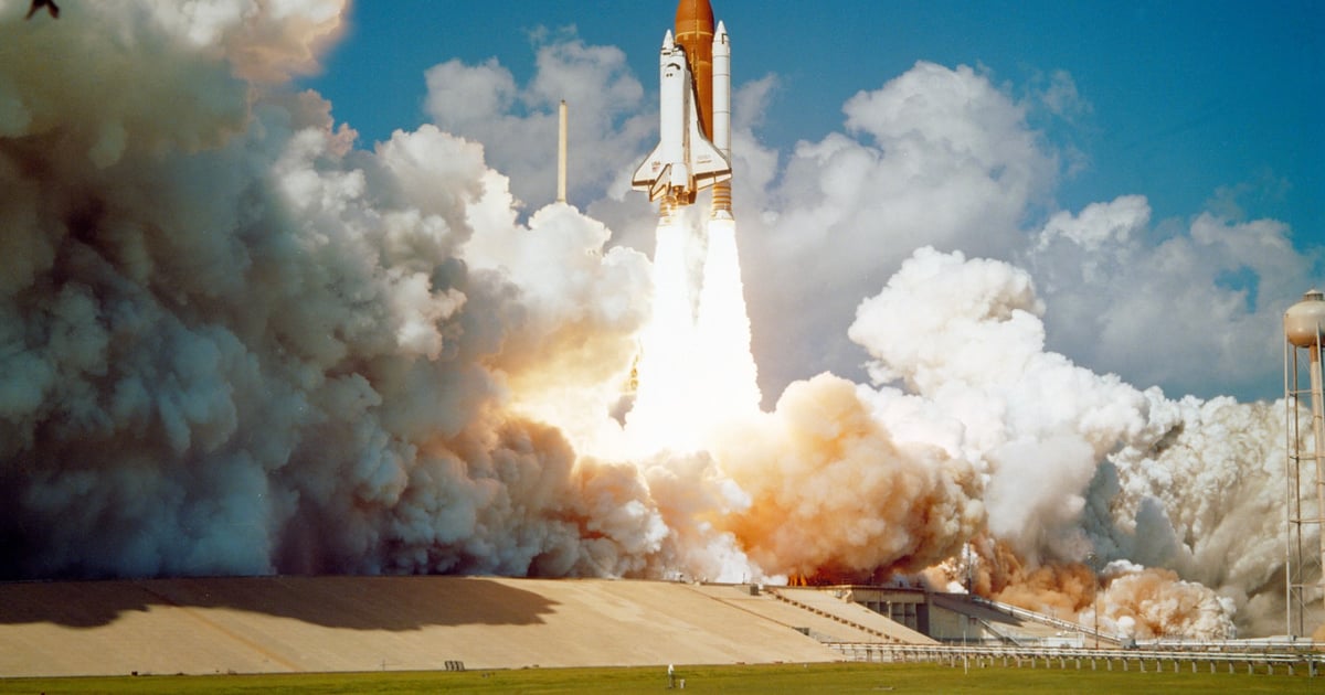 Space shuttle lifting off surrounded by huge clouds of smoke