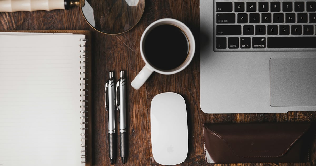 Top 7 Productivity Chrome Extensions for Students in 2023 - Desk showing Macbook, Coffee, Pen & Paper, and magnifiers